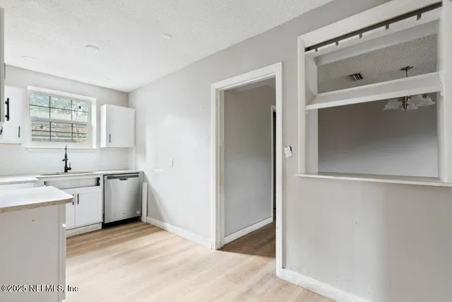 a view of a kitchen with white cabinets and white appliances