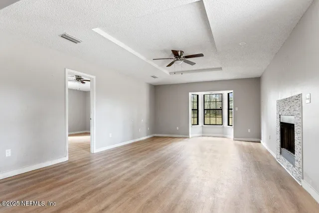 a view of an empty room with a fireplace and a window