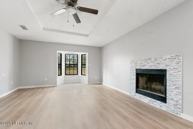 a view of an empty room with a fireplace and a window