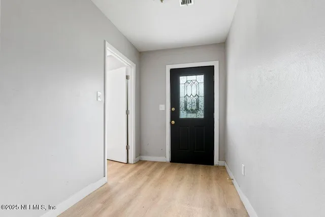 a view of an empty room with closet and a window