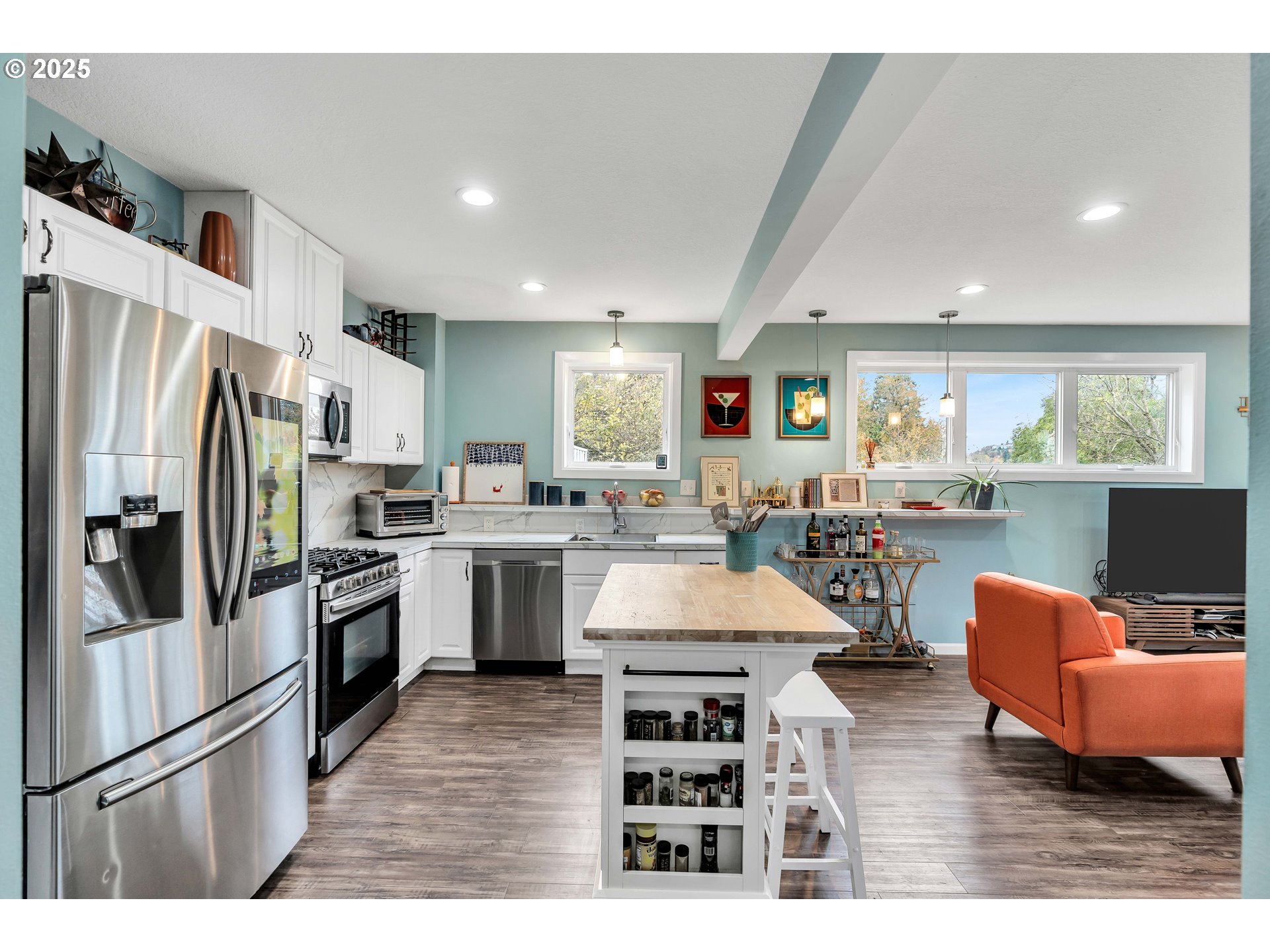 704 3rd Avenue Oregon City, OR 97045 - Photo 14 of 48 a living room with stainless steel appliances kitchen island granite countertop a refrigerator a stove a sink dishwasher and a dining table with wooden floor