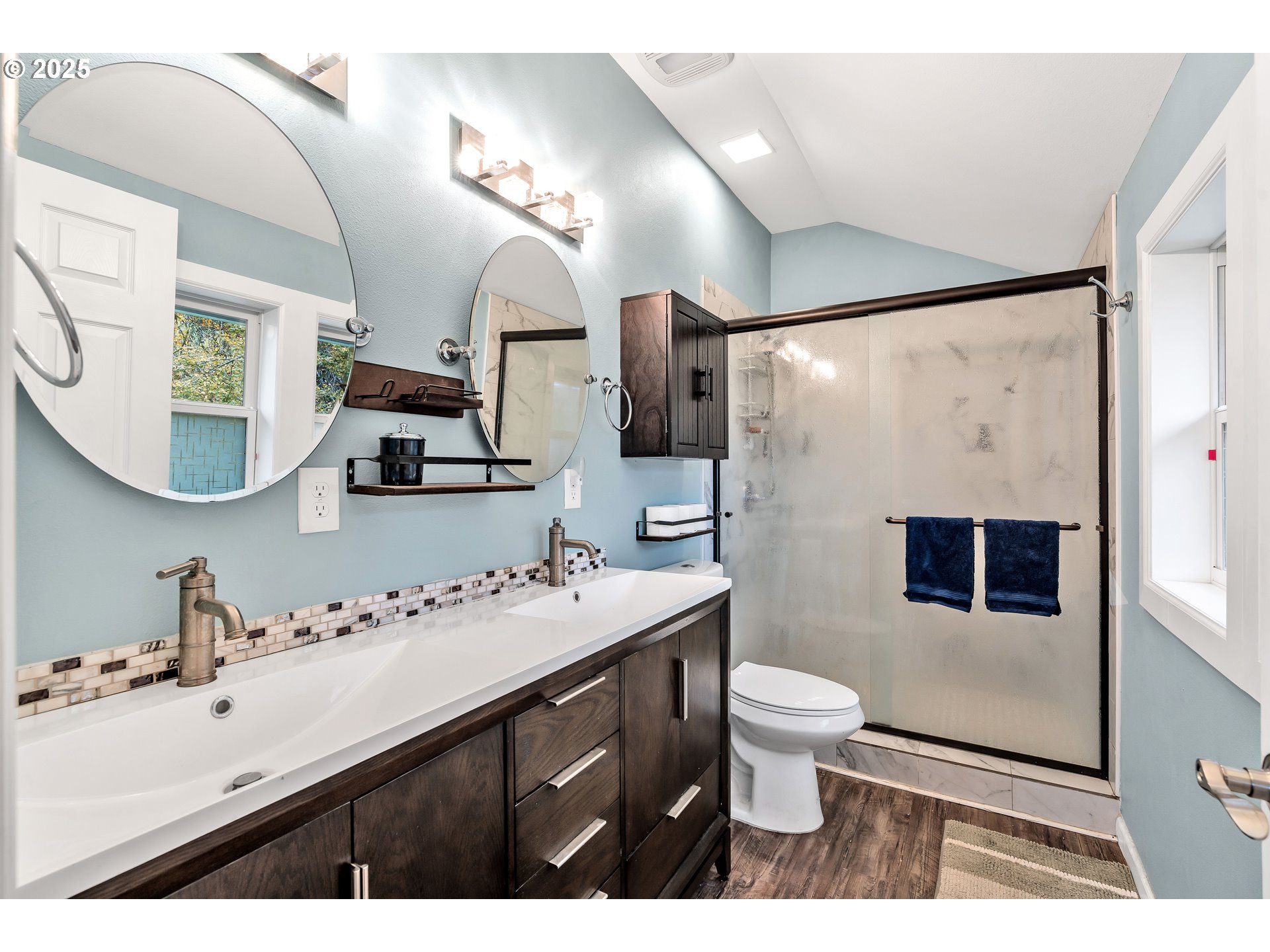 704 3rd Avenue Oregon City, OR 97045 - Photo 25 of 48 a bathroom with a sink a toilet a mirror a vanity and shower