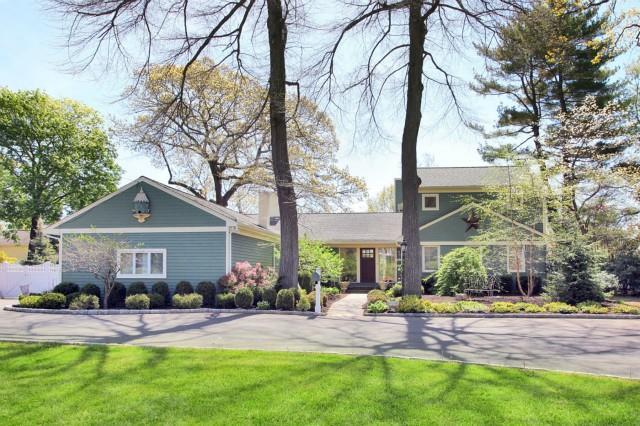 a front view of a house with yard and green space