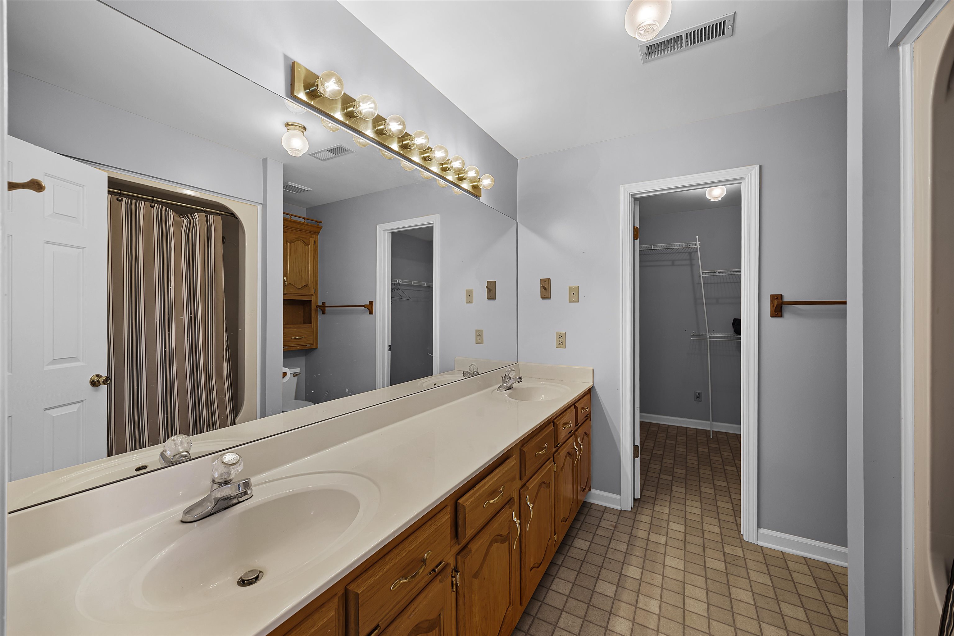 80 Riviera Cove Cherokee, AL 35616 - Photo 13 of 31 Bathroom featuring double vanity, light tile patterned floors, a spacious closet, and curtained shower