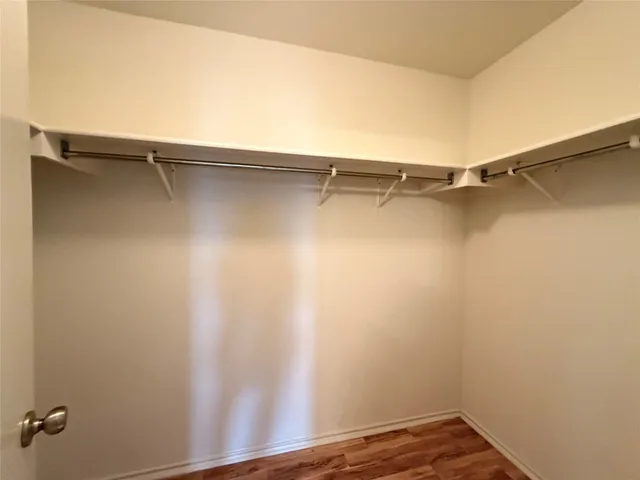 a view of walk in closet with empty racks