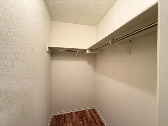 a view of walk in closet with empty racks