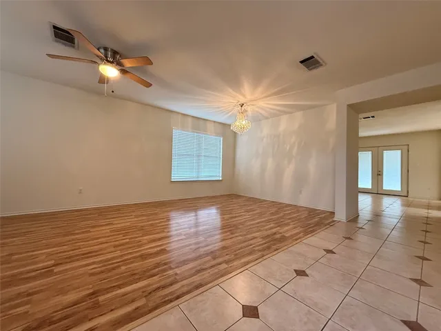 a view of an empty room with glass door and a window