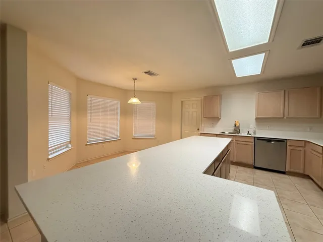 a large white kitchen with kitchen island a sink dishwasher stove and cabinets