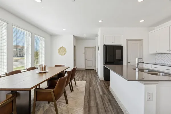 a kitchen with a table chairs stove and refrigerator