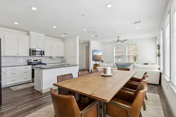 a kitchen with a table chairs sink and cabinets