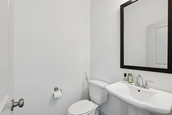 a bathroom with a toilet sink and mirror