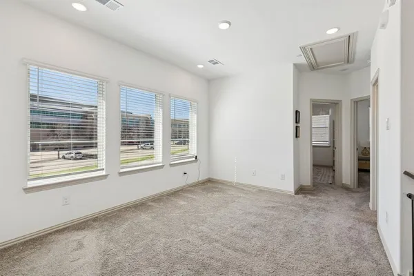 an empty room with a cabinet and mirrors