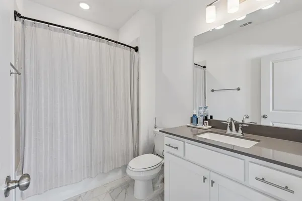 a bathroom with a granite countertop sink toilet and a mirror