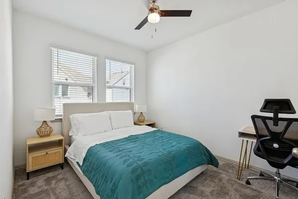 a bedroom with a bed a chair and a chandelier