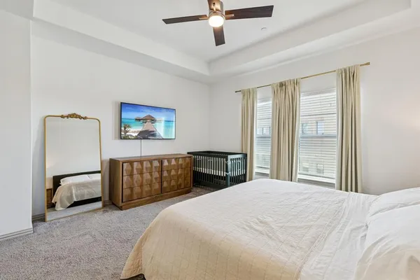 a bedroom with a large bed and a chandelier
