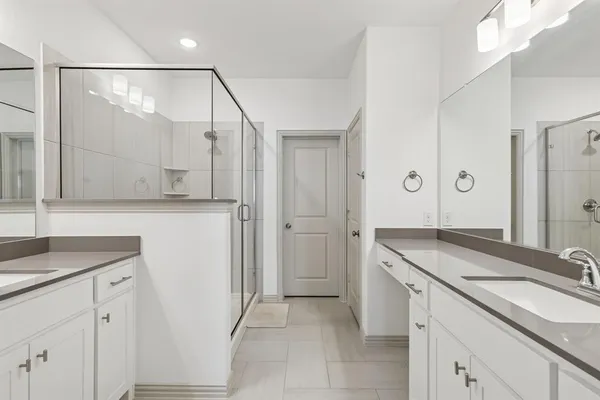 a bathroom with a granite countertop sink a mirror and a shower