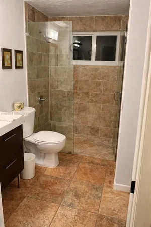 a bathroom with a toilet and a shower