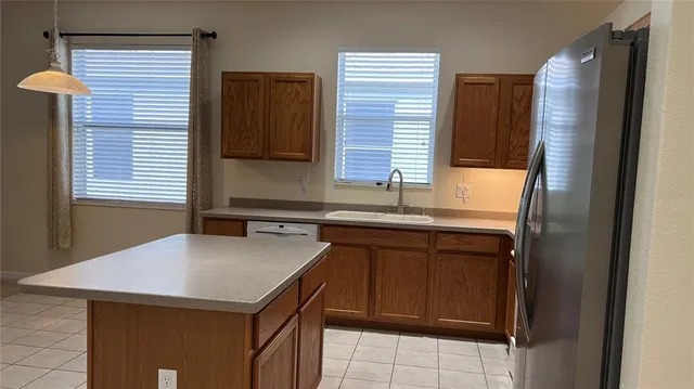 a kitchen with a sink refrigerator and microwave
