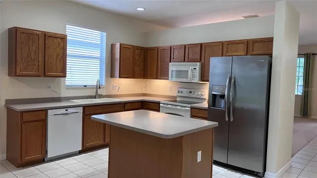 a kitchen with a refrigerator sink and cabinets