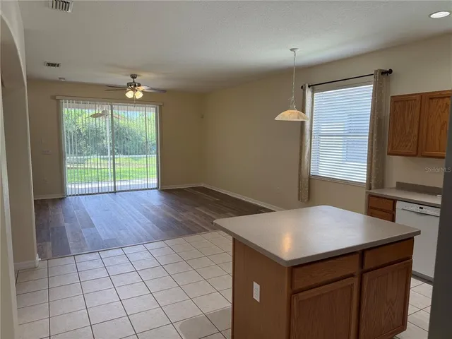 a kitchen with granite countertop a stove a sink and a refrigerator
