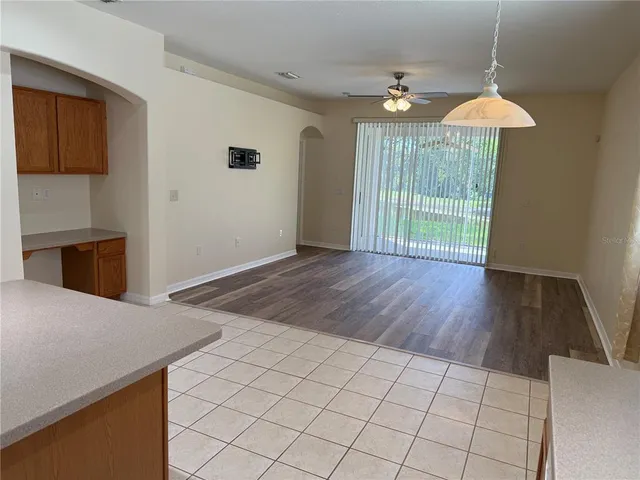 a view of a room with wooden floor exposed radiator and a chandelier