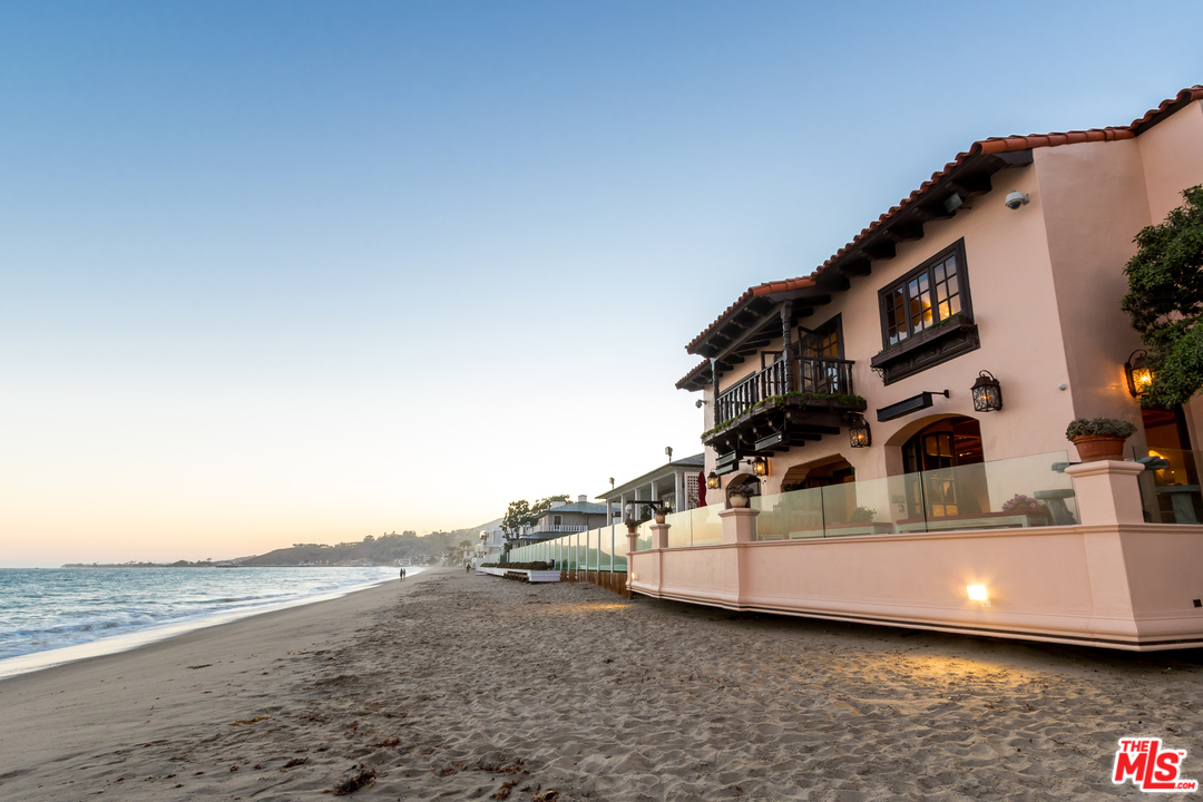 22102 Pacific Coast Highway Malibu, CA 90265 - Photo 34 of 36 a white building with a large window and palm tree