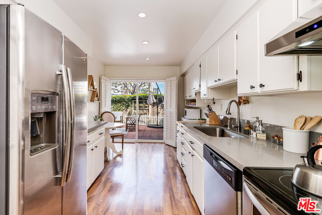 4443 Saugus Avenue, Unit 3 Sherman Oaks, CA 91403 - Photo 13 of 35 a kitchen with stainless steel appliances a sink a stove and refrigerator
