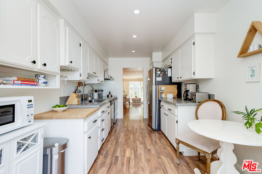 4443 Saugus Avenue, Unit 3 Sherman Oaks, CA 91403 - Photo 18 of 35 a kitchen with a white stove top oven and white cabinets
