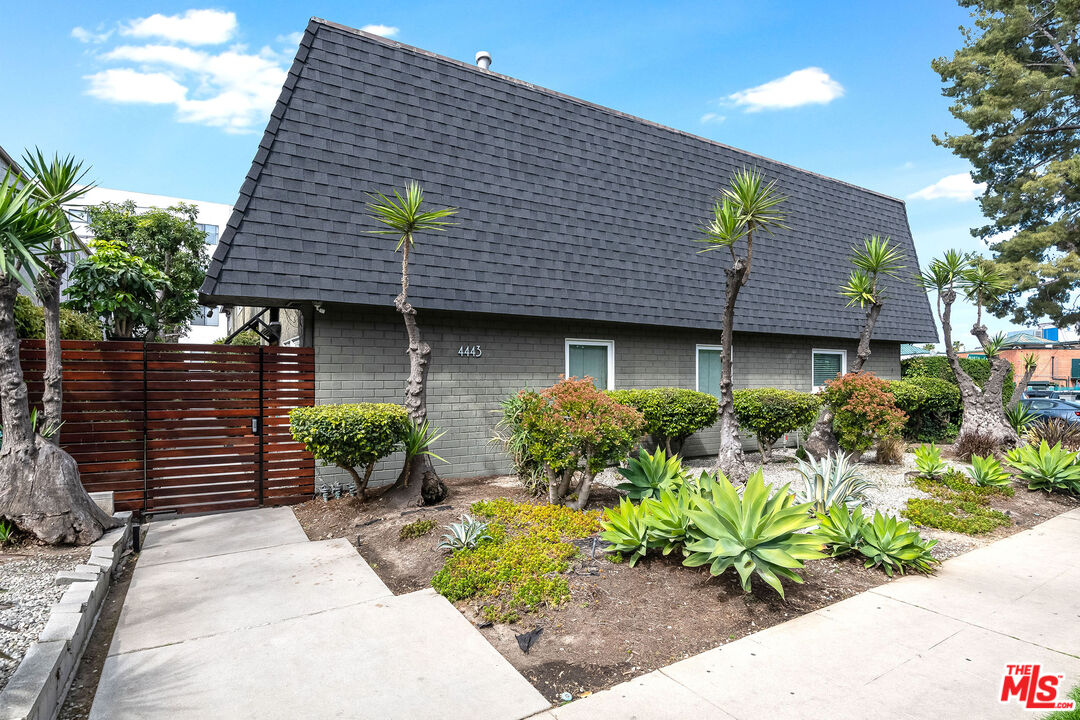 4443 Saugus Avenue, Unit 3 Sherman Oaks, CA 91403 - Photo 2 of 35 a front view of a house with a garden