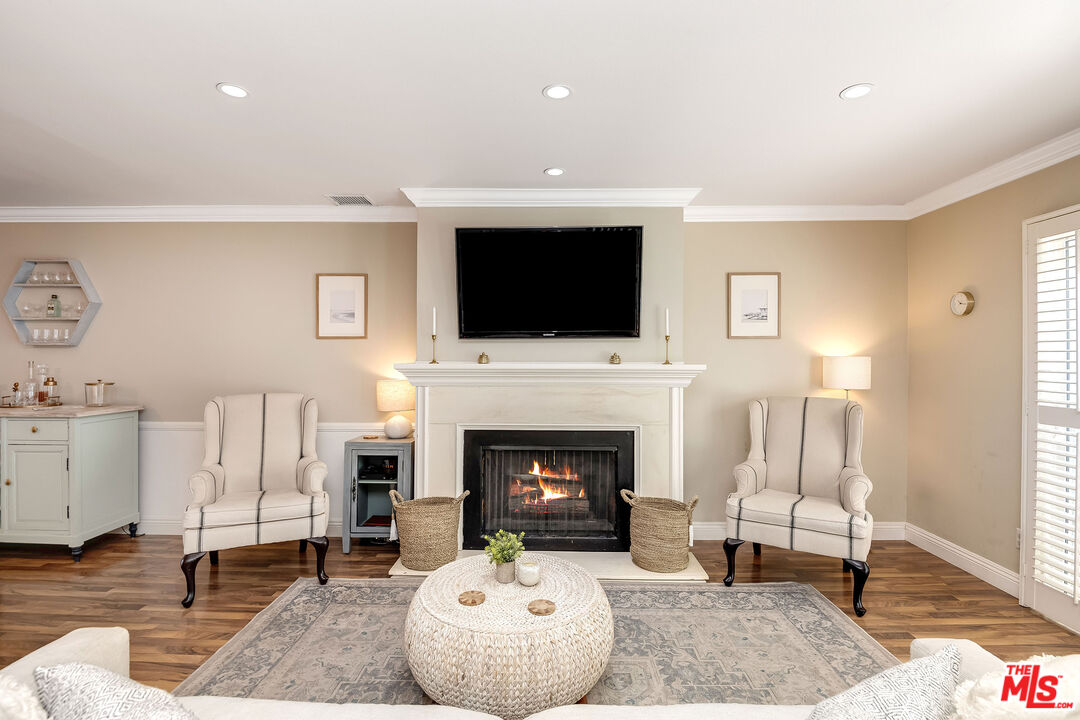 4443 Saugus Avenue, Unit 3 Sherman Oaks, CA 91403 - Photo 7 of 35 a living room with furniture a fireplace and a flat screen tv