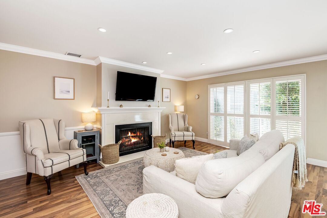 4443 Saugus Avenue, Unit 3 Sherman Oaks, CA 91403 - Photo 8 of 35 a living room with furniture a fireplace and a flat screen tv