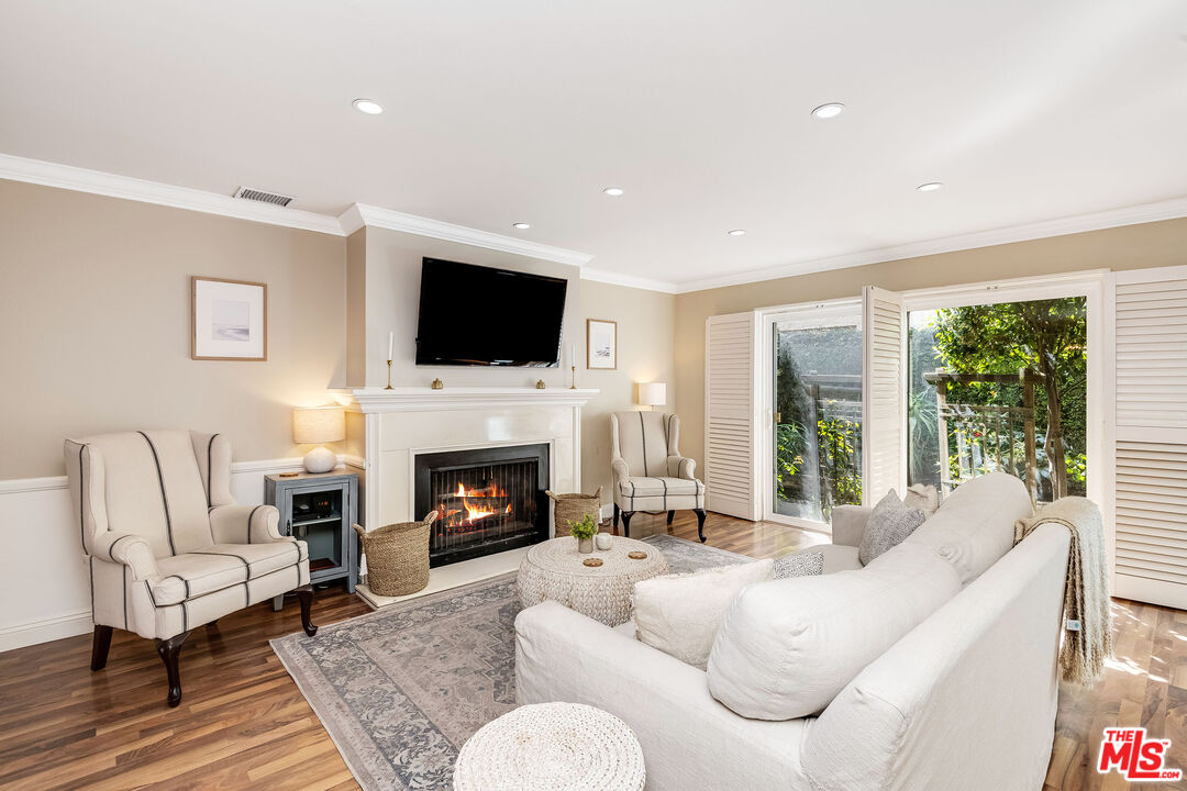 4443 Saugus Avenue, Unit 3 Sherman Oaks, CA 91403 - Photo 9 of 35 a living room with furniture a fireplace and a flat screen tv