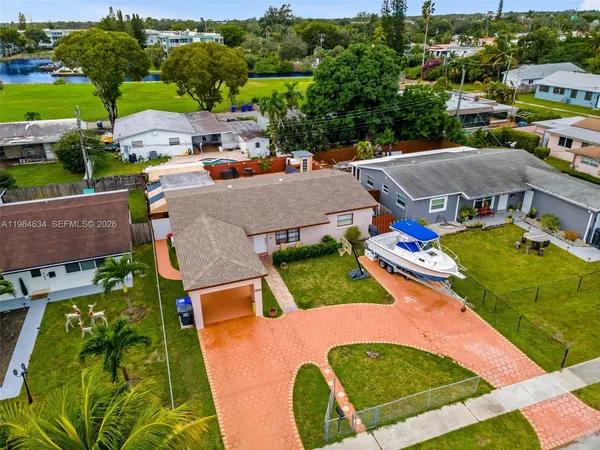 an aerial view of residential houses with outdoor space and swimming pool