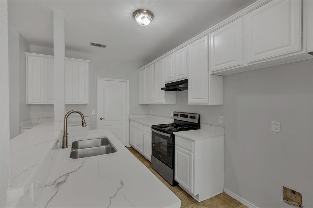 711 Parkplace Ridge Princeton, TX 75407 - Photo 8 of 15 a kitchen with stainless steel appliances a sink a stove and a refrigerator