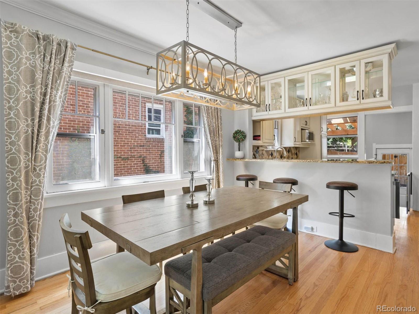 643 Jackson Street Denver, CO 80206 - Photo 12 of 40 a view of a dining room with furniture a chandelier and wooden floor