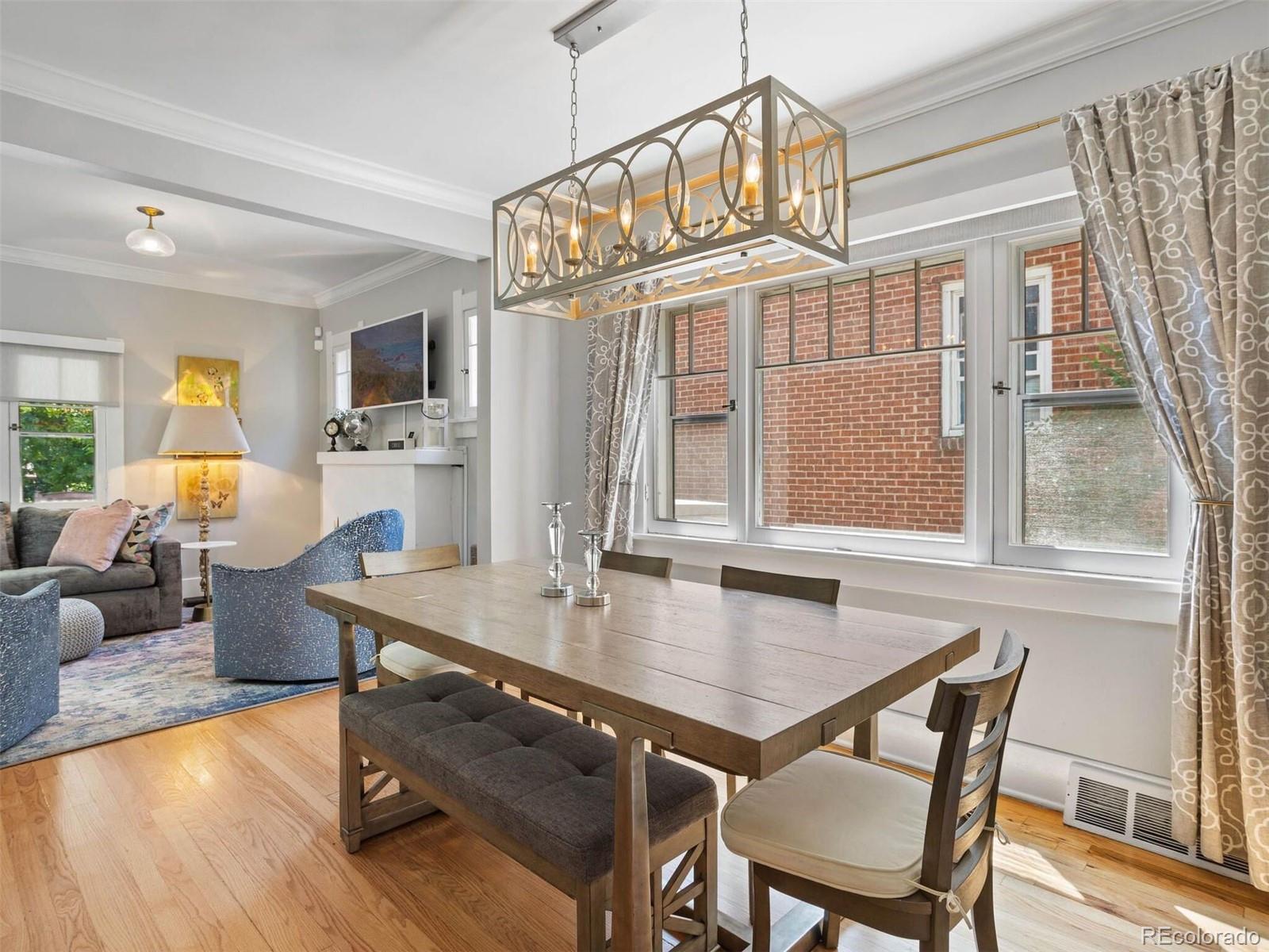 643 Jackson Street Denver, CO 80206 - Photo 13 of 40 a dining room with wooden floor a chandelier a wooden table and chairs