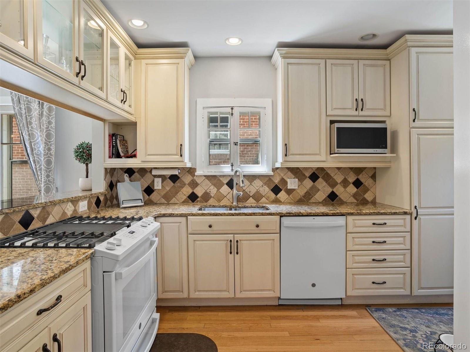 643 Jackson Street Denver, CO 80206 - Photo 15 of 40 a kitchen with granite countertop a sink stove and cabinets