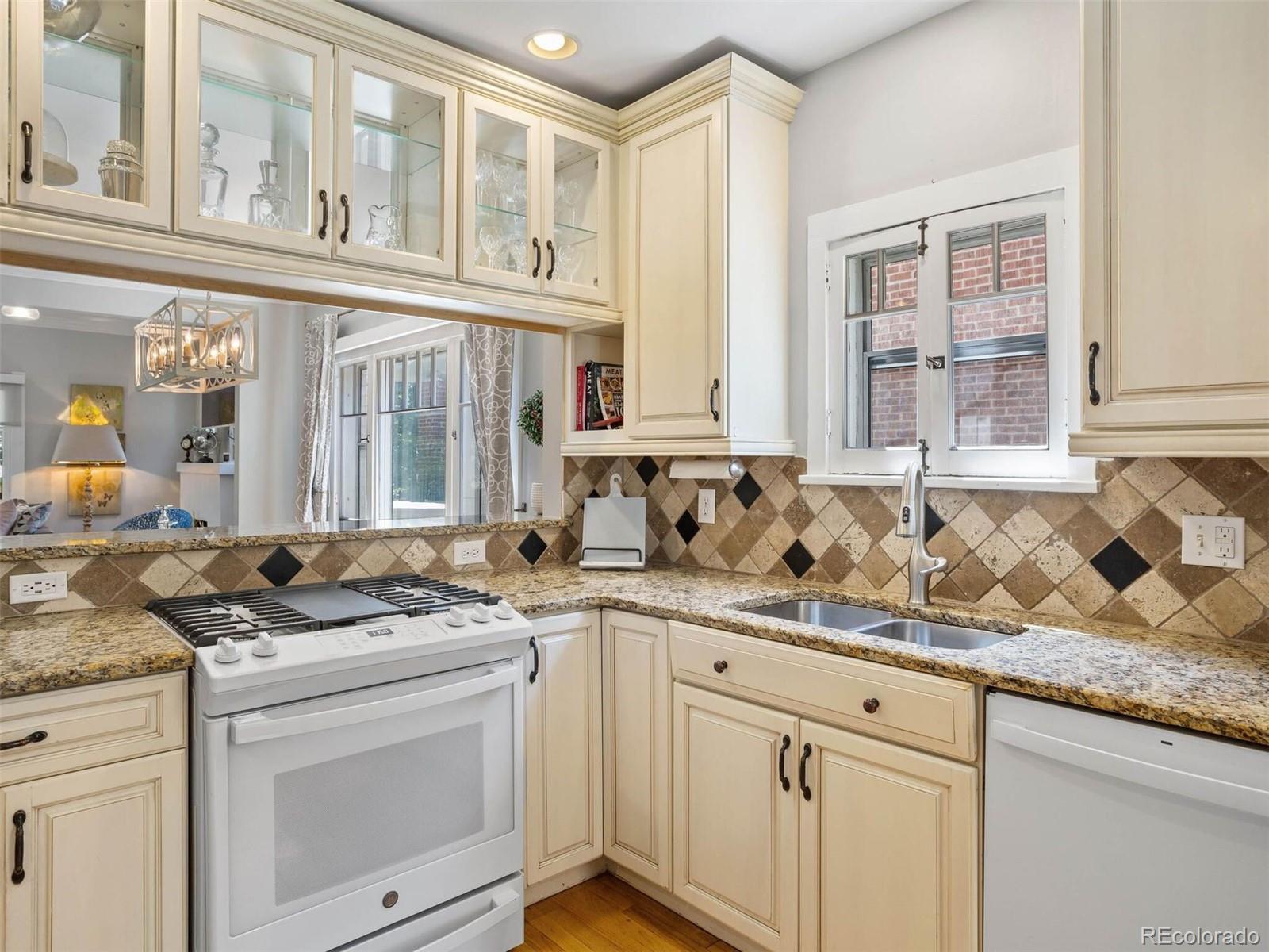 643 Jackson Street Denver, CO 80206 - Photo 17 of 40 a kitchen with granite countertop a sink stove and cabinets