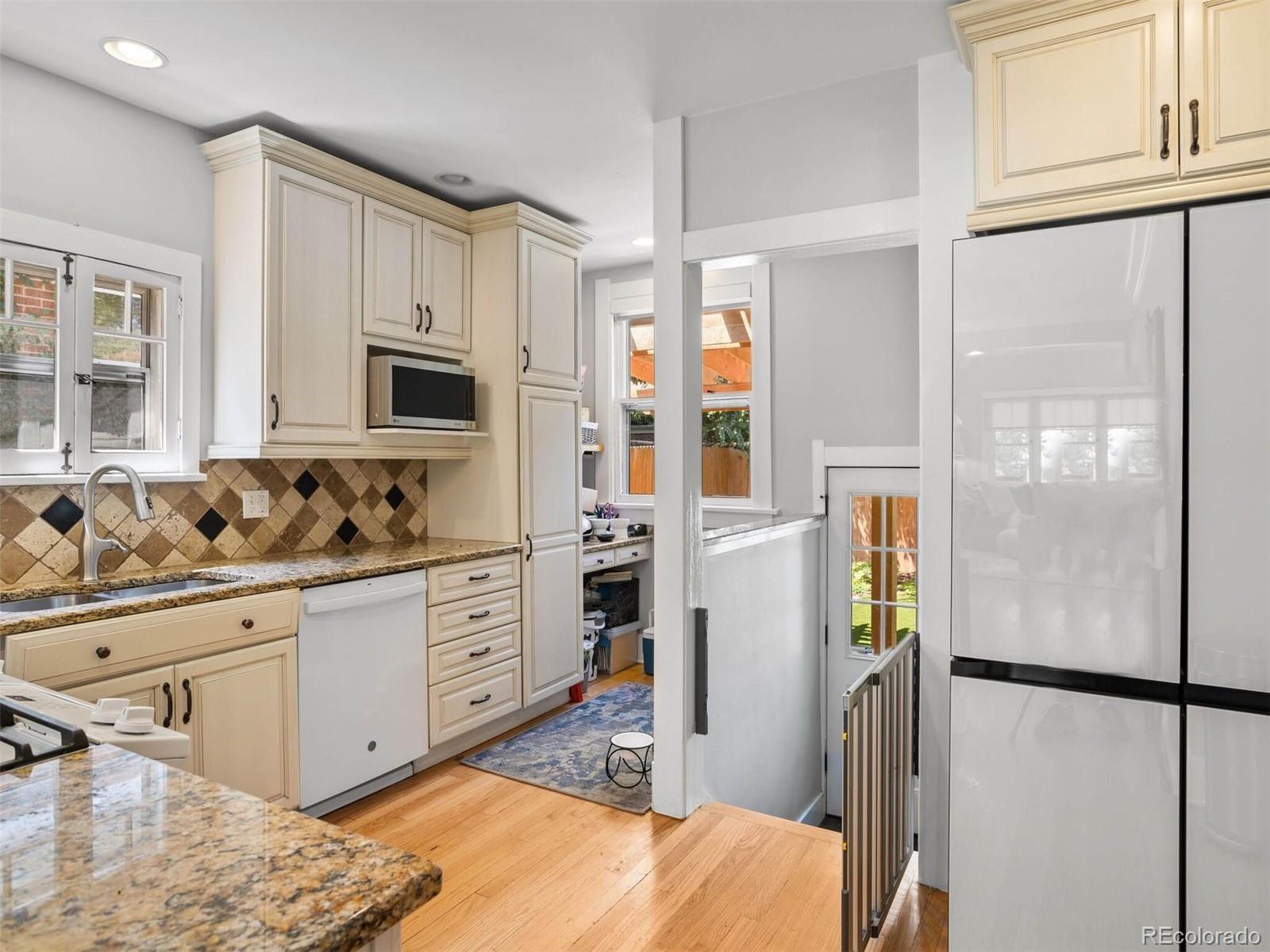 643 Jackson Street Denver, CO 80206 - Photo 18 of 40 a kitchen with stainless steel appliances a refrigerator sink and cabinets