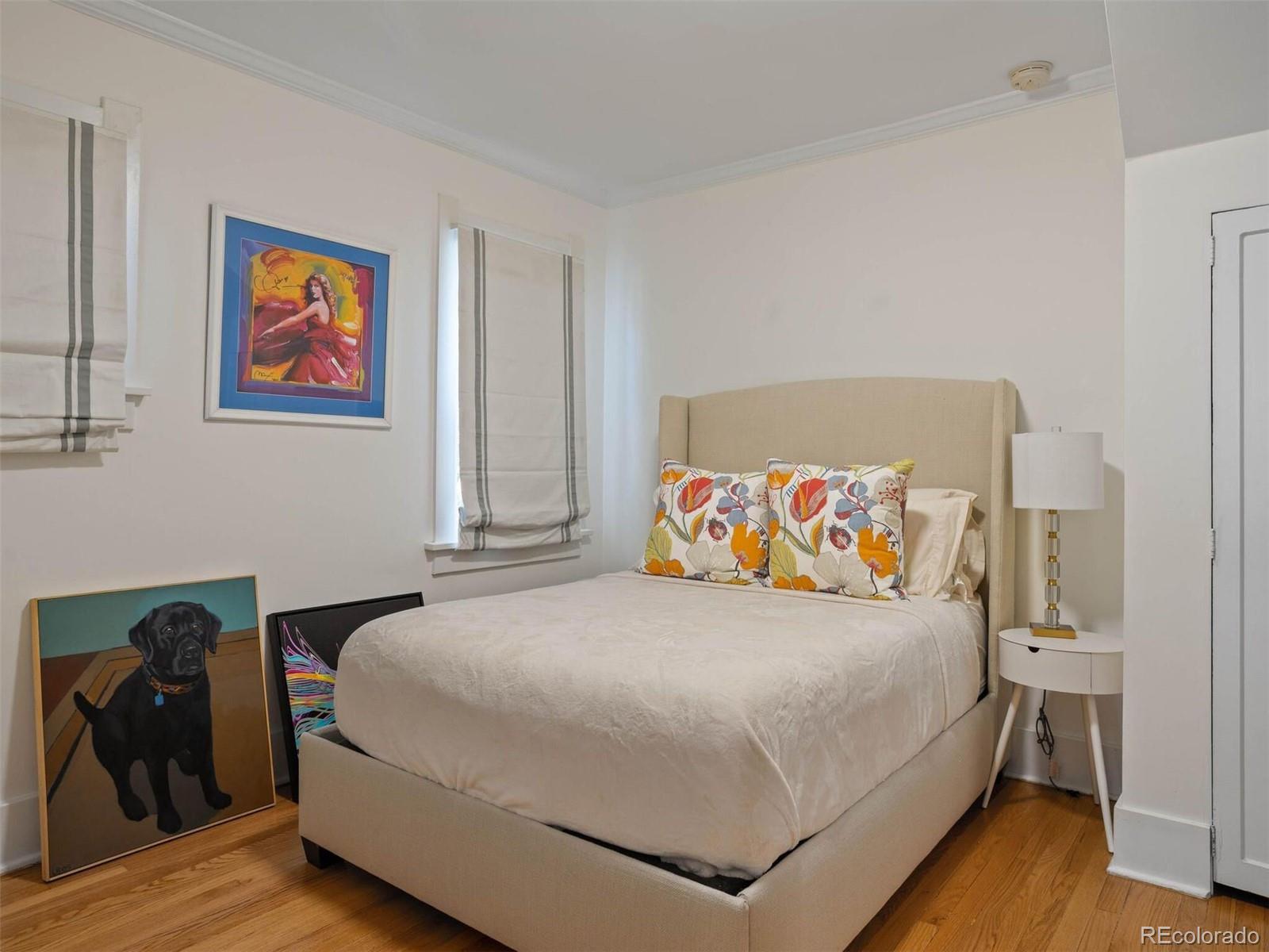 643 Jackson Street Denver, CO 80206 - Photo 21 of 40 a bedroom with a bed and a painting on the wall