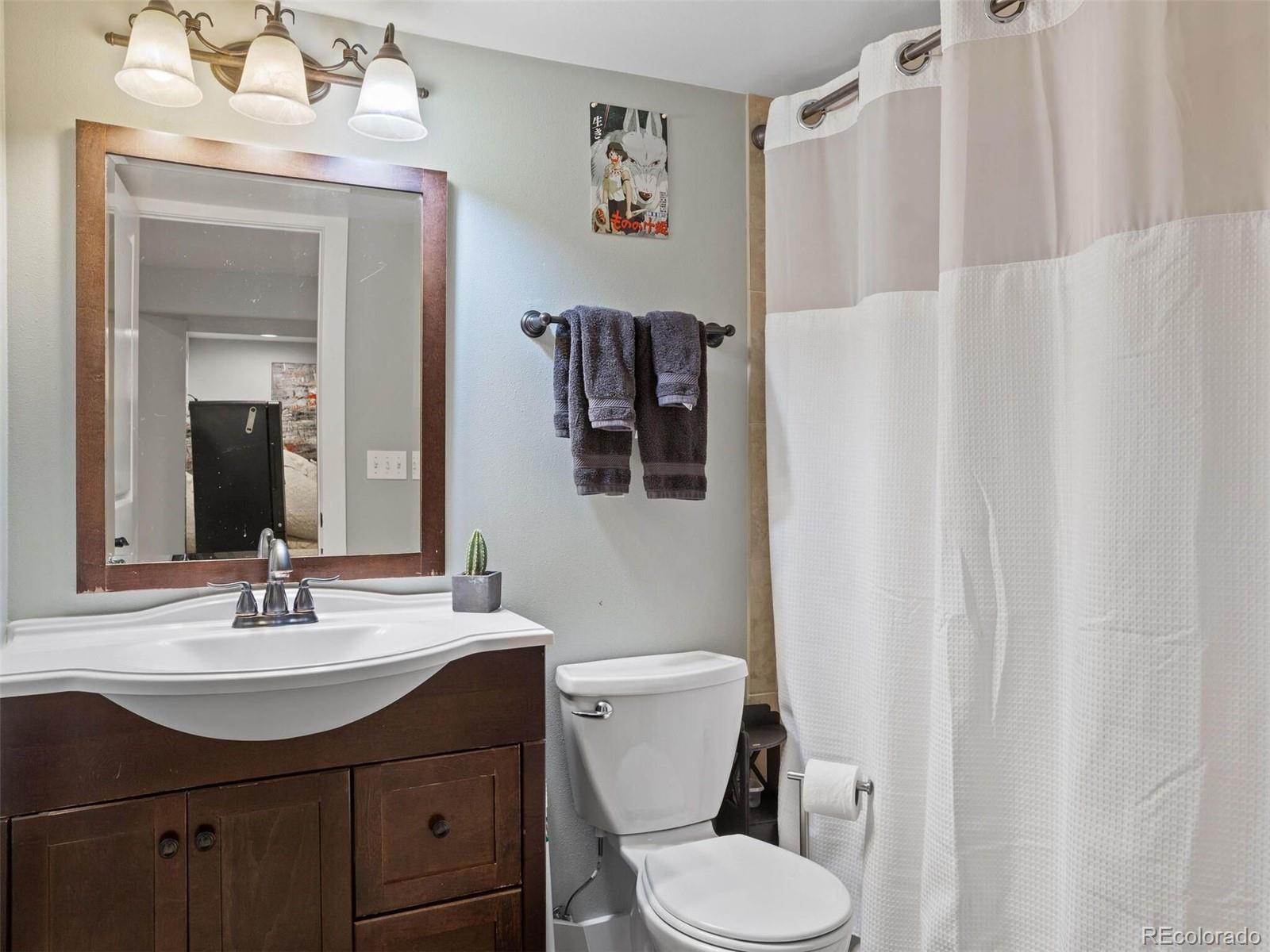 643 Jackson Street Denver, CO 80206 - Photo 35 of 40 a bathroom with a sink vanity mirror and toilet
