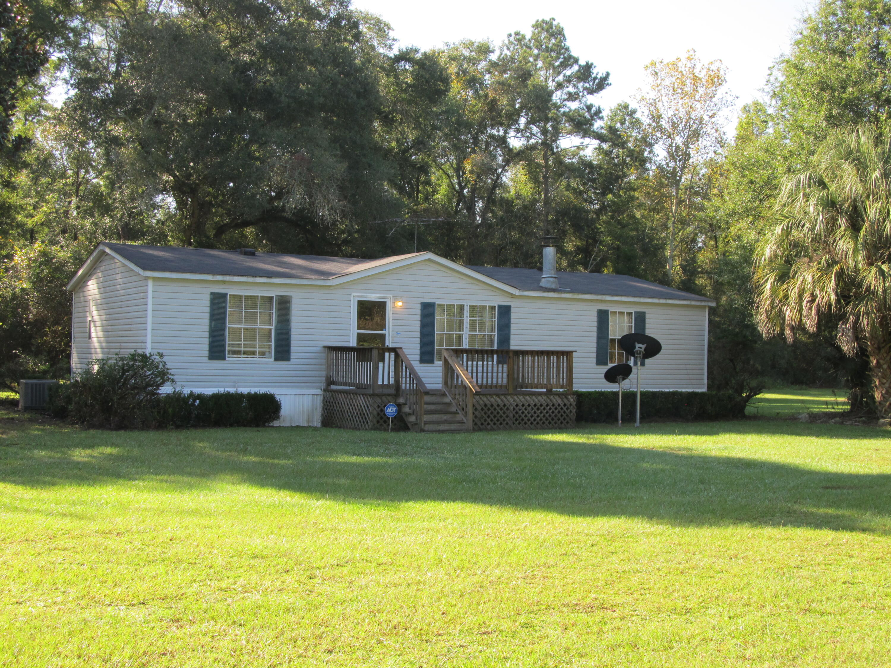 211 River Road Samson, AL 36477 - Photo 18 of 23 a front view of a house with a yard and trees