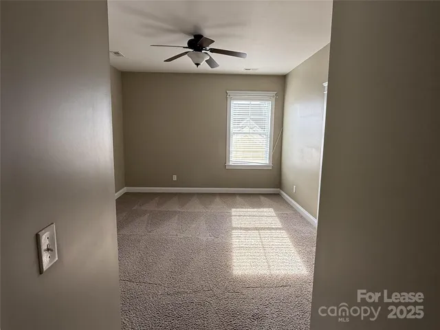 a view of room with a ceiling fan and window