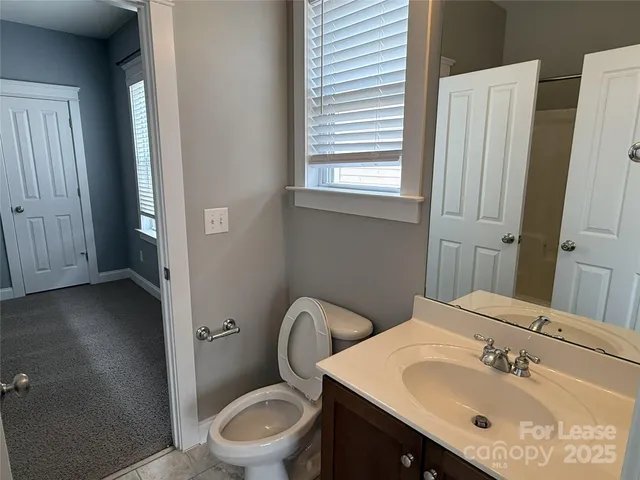 a bathroom with a sink vanity mirror and toilet