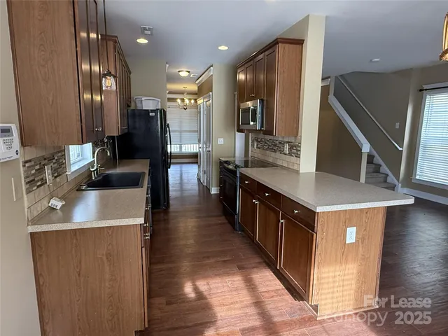 a large kitchen with stainless steel appliances a sink and cabinets