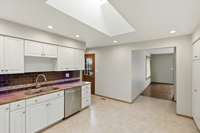 a kitchen with granite countertop a sink and cabinets