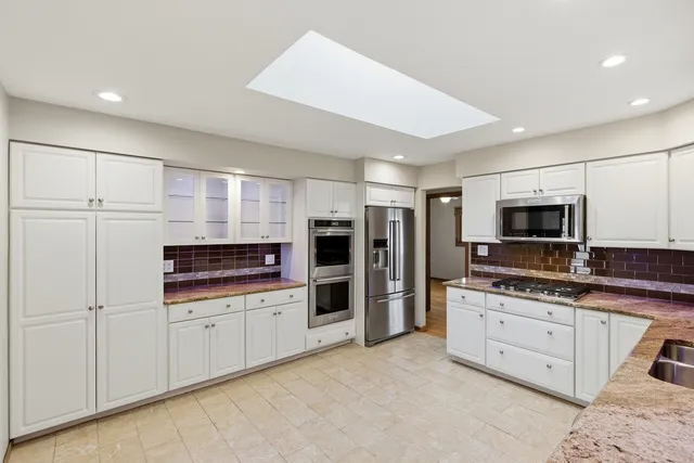 a kitchen with stainless steel appliances a refrigerator and a stove top oven