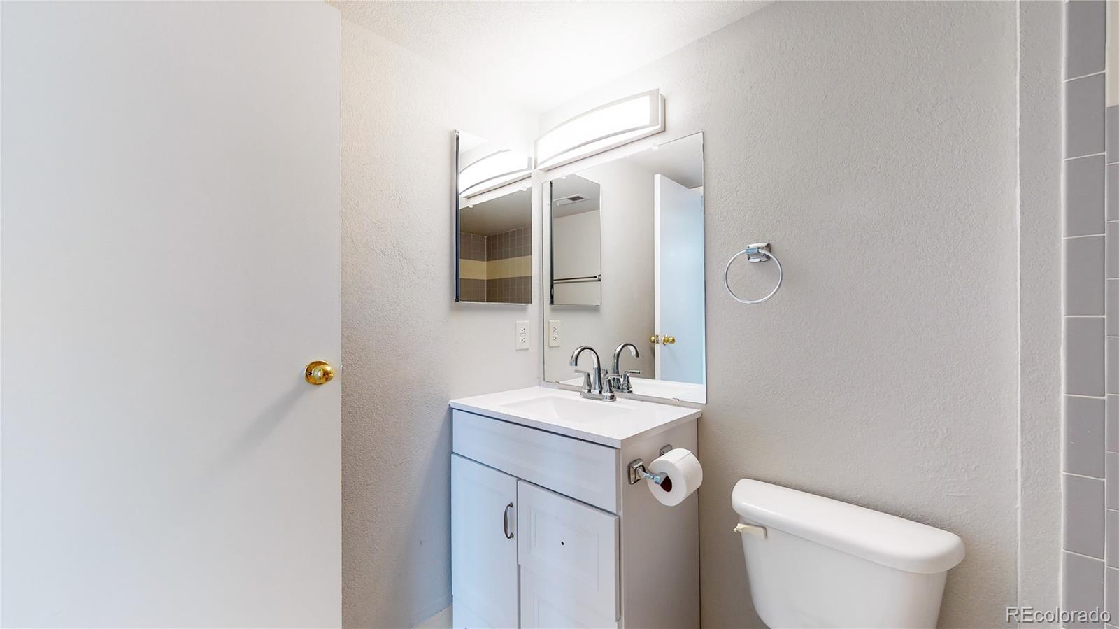 4760 South Wadsworth Boulevard, Unit F208 Littleton, CO 80123 - Photo 15 of 30 a bathroom with a toilet sink and mirror