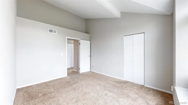 an empty room with closet and mirror