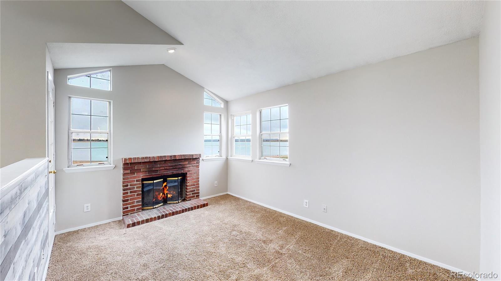 4760 South Wadsworth Boulevard, Unit F208 Littleton, CO 80123 - Photo 2 of 30 an empty room with windows and fireplace